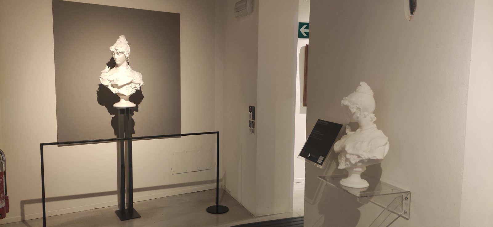 A 3D-printed copy of a bust next to the original in the gallery